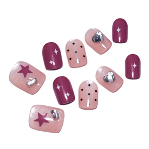 Pink and deep red press-on nails with star patterns, dots, and silver heart rhinestones