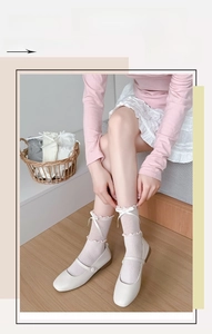 Detail of white ruffle socks with bow accents and ribbed texture in sweet Lolita style