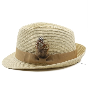 Detail of light beige straw fedora with brown grosgrain ribbon and feather accessory