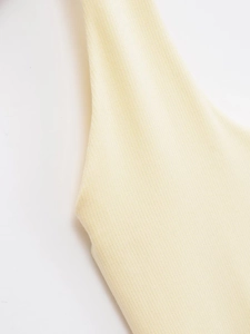 Détail de la texture en maille côtelée jaune clair et des coutures de la bandoulière