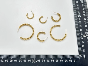 Detailed set of six gold twisted hoop earrings in various sizes with scale measurement