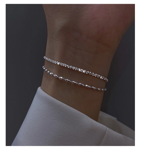 Close-up of sparkling double-layer silver bracelet on wrist with elegant bead and zircon details