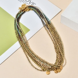 Detailed close-up of bohemian multi-layer beaded necklace with gold hammered coin pendants