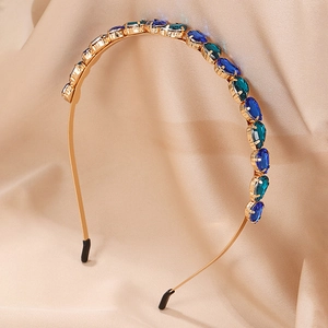Golden headband with blue crystal heart gems on champagne satin background