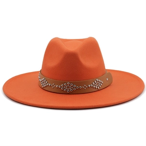 Detail of orange wool fedora with brown leather band and silver rivet studs