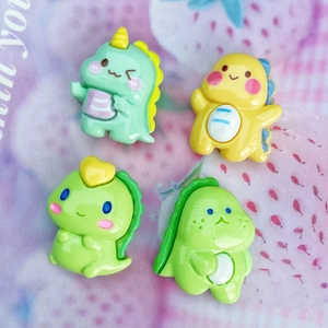 Set of four glossy cartoon dinosaur resin charms in green and yellow for DIY projects