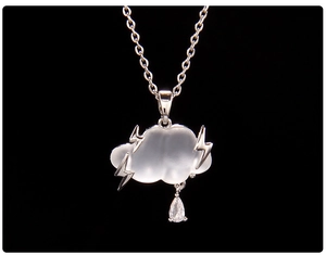 Detailed view of cloud necklace with silver lightning bolts and a teardrop crystal charm