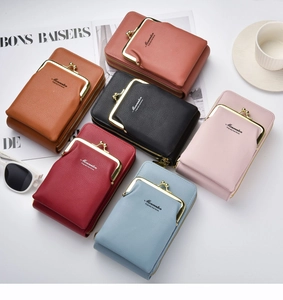 Vue à plat de sacs à bandoulière colorés en cuir grainé dans un décor de style de vie chic