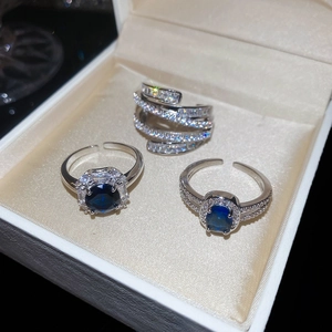 Detailed view of three silver rings set with blue gemstone and cubic zirconia