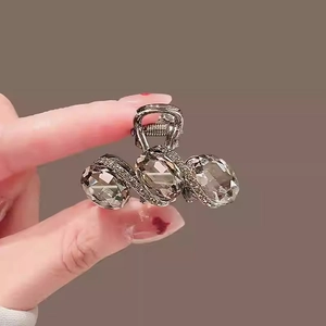 Detailed macro view of dark metal hair claw clip with large crystals and tiny rhinestones