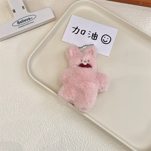 Close-up of pink plush rabbit pendant with quirky teeth detail and silver bead chain