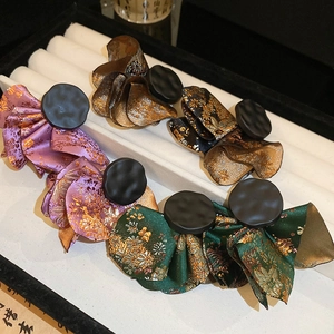 Detailed view of satin embroidered hair clips in four traditional patterns on display