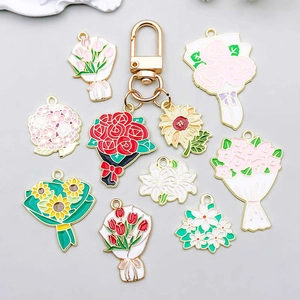 White enamel rose and lily flower charms on a golden metal keychain with floral pendants