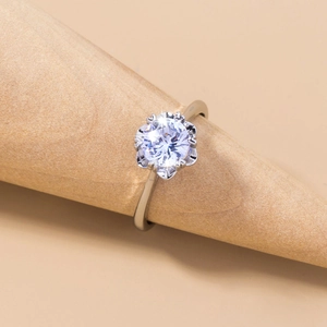 Macro detail of a silver ring with a clear zircon stone on a wooden display stand