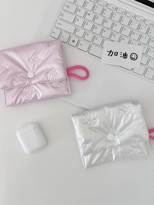 Quilted bow embroidery coin pouches in pink and silver on a minimalist white desk