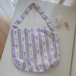 Detail of lavender floral print and textured polka dots on a striped cotton tote bag