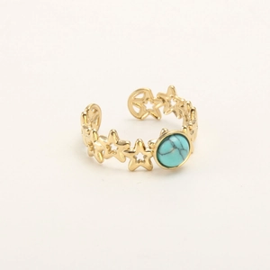 Detail of adjustable gold ring featuring cutout stars and a turquoise center stone