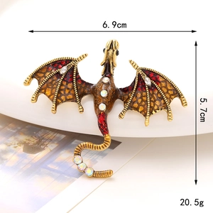 Macro shot of vintage dragon brooch with gold alloy, red enamel and white rhinestones