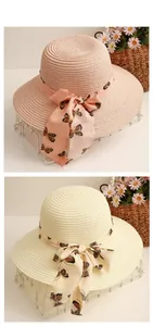 Flache Ansicht von gewebten Sonnenhüten mit Schmetterlings-Chiffonschleifen in Rosa und Beige