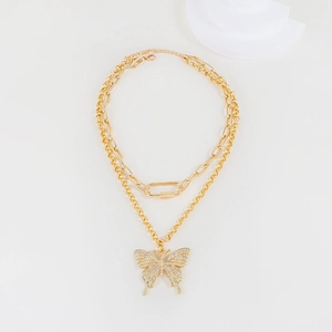 Detailed close-up of a double-layered golden chain necklace with rhinestone butterfly charm