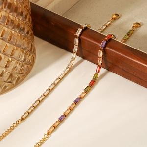Detail of 18K gold plated bracelets with white and multicolor baguette-cut zircons
