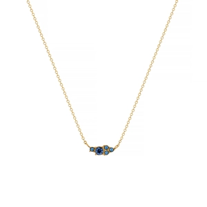Detail of gold chain necklace featuring a clustered deep blue gemstone pendant