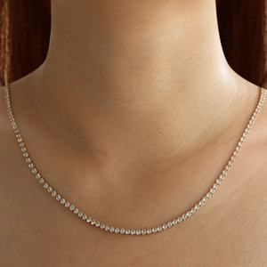 Gros plan d'un collier en chaîne plaqué or 18K avec zircons micro-sertis sur le cou