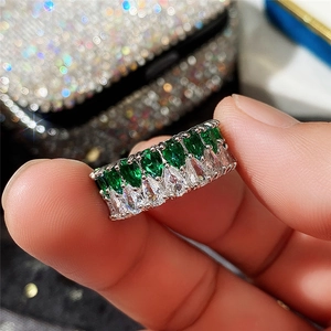 Détail d'une bague argentée avec double rangée de zircons émeraude et transparents