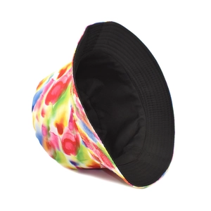 Detail of reversible tie-dye bucket hat showing colorful print and solid black lining