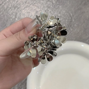 Dettaglio di una molletta per capelli a fiore in metallo argento con finitura lucida