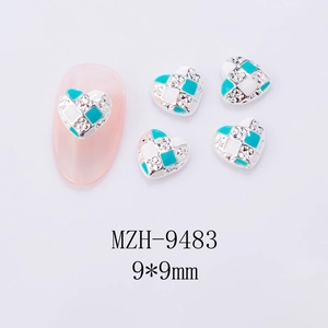 Detail showing a 9x9mm Y2K checkerboard heart nail charm with teal enamel and rhinestones