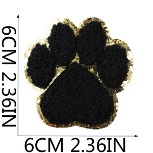 Detailed view of dog paw patch with black chenille embroidery and gold sequins, 6cm size