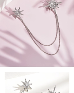 Close-up of silver starburst brooch with double layered chains and sparkling zircons
