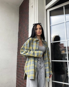 Detailed street style view of casual plaid button-down shirt with high-waist jeans