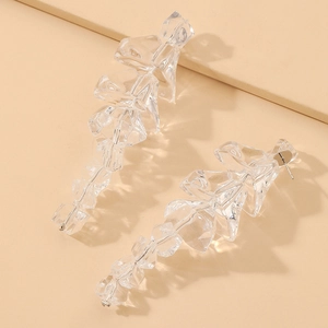 Macro detail of irregular transparent acrylic ice cube drop earrings with silver pins