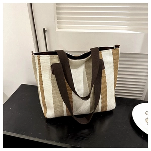 Close-up of the striped canvas tote bag showing wide vertical stripes and brown handles