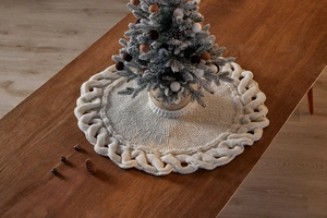 Close-up of cream knit mini Christmas tree skirt with cable weave pattern on wooden table