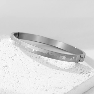 Dettaglio macro del bracciale in acciaio argento con stelle incise su pietra strutturata