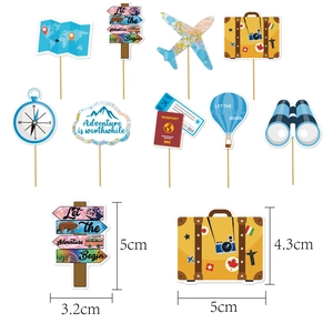 Macro view of travel themed cake toppers with dimensions for suitcases and signposts