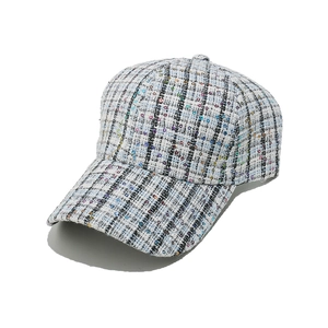 Detailed close-up of textured tweed baseball cap with colorful sequins and weaving