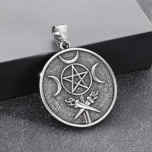 Macro detail of gothic pentagram pendant with triple moon and snake engraving on steel