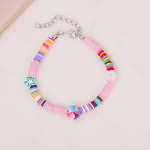 Colorful bohemian handmade beaded bracelet with heart and star charms on fabric background