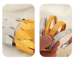 Detail of gold and silver leaf pattern cuffs and textured geometric stackable bangles