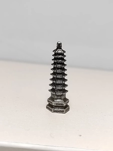 Macro shot of miniature metal Wen Chang pagoda with aged silver finish and hexagonal base