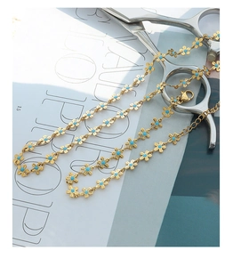 Detail of gold floral necklace with sky blue enamel petals and lobster clasp closure
