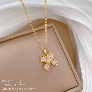 Detailed close-up of a gold titanium necklace with X-shaped sparkling zircon pendant