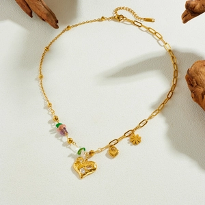 Gold plated stainless steel necklace with heart pendant and colorful stones on wood