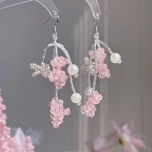 Détail de perles en cristal rose et de perles blanches sur de longues boucles