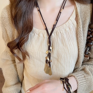 Detail of bohemian metal droplet tassel necklace and bracelet set on a model