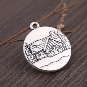 Antique silver round pendant featuring embossed snow-covered cabin on wood texture